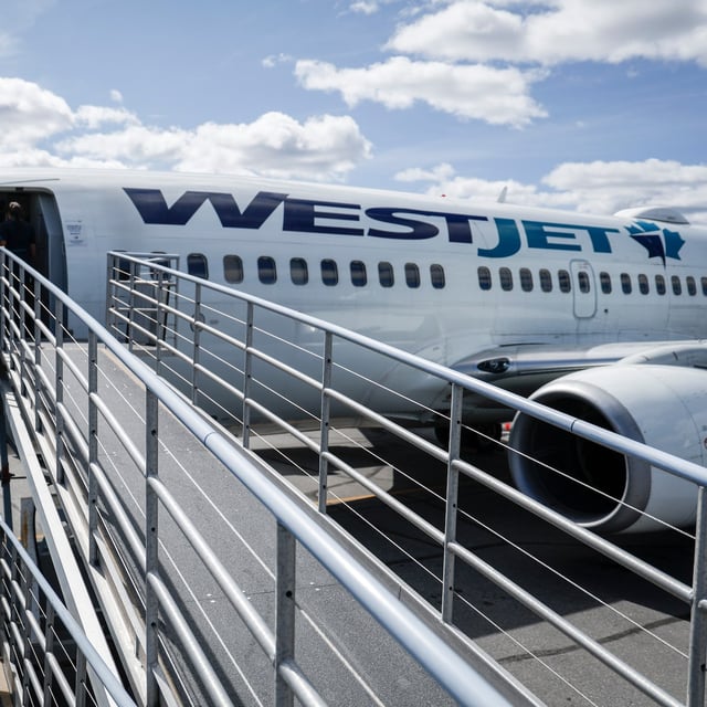 WestJet passengers deplane on the tarmac at Yellowknife Airport on Tuesday, July 22, 2025. THE CANADIAN PRESS/Jeff McIntosh