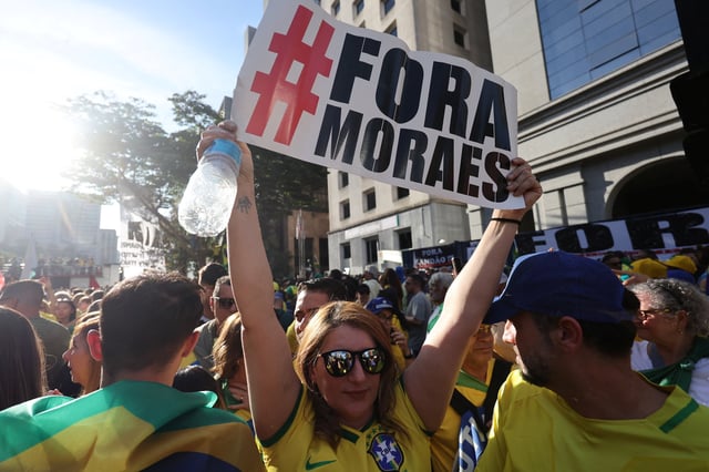 A person holds a sign reading "Fora Moraes" (Out with Moraes), referring to Brazilian Supreme Court Justice Alexandre de Moraes, during a demonstration against the Supreme Court's measures in the trial of former Brazilian President Jair Bolsonaro, at the Paulista avenue in Sao Paulo, Brazil August 3, 2025. REUTERS/Jorge Silva