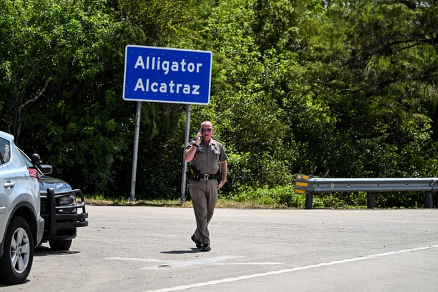 A Florida Highway Patrol officer looks on as protesters gather to demand the closure of the immigrant detention center known as &#34;Alligator Alcatraz&#34; at the Dade-Collier Training and Transition Airport in Ochopee, Florida, on July 22, 2025.