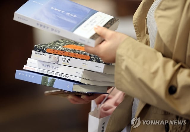 A woman buys Nobel laureate Han Kang's books at Kyobo Book Store in Gwanghwamun, Seoul, in this Oct. 15, 2024, file photo. (Yonhap)