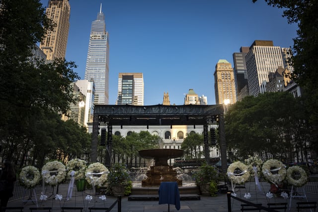 Flower wreaths with the words "Rest In Peace" stand at a vigil for the four people killed in the previous day's shooting at 345 Park Avenue, including NYPD officer Didarul Islam, in Bryant Park, Tuesday, July 29, 2025, in New York. (AP Photo/Angelina Katsanis)