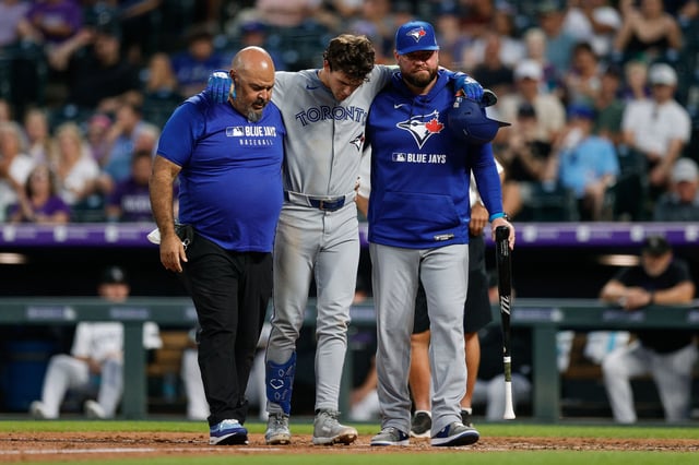 Aug 5, 2025; Denver, Colorado, USA; Toronto Blue Jays left fielder Joey Loperfido (C) is helped off the field by head athletic trainer Jose Ministral (L) and manager John Schneider (R) in the sixth inning against the Colorado Rockies at Coors Field. Mandatory Credit: Isaiah J. Downing-Imagn Images