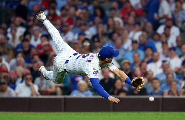 Chicago Cubs second baseman Nico Hoerner (2) is unable to make a play on a ball that went for an infield single for Cincinnati Reds center fielder TJ Friedl in the fourth inning of a game at Wrigley Field in Chicago on Aug. 5, 2025.  (Chris Sweda/Chicago Tribune)