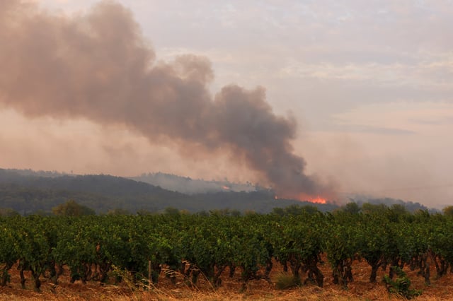 Smoke rises during a wildfire at sunrise near Saint-Laurent-de-la-Cabrerisse, near Narbonne, southern France, August 6, 2025. REUTERS/Manon Cruz