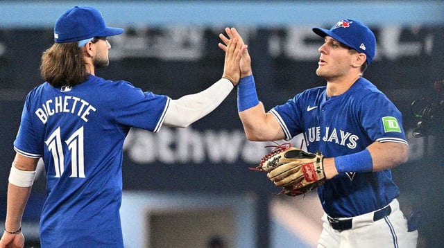 Apr 13, 2024; Toronto, Ontario, CAN; Toronto Blue Jays left fielder Daulton Varsho (25) celebrates with shortstop Bo Bichette (11) after a win over the Colorado Rockies at Rogers Centre. Mandatory Credit: Dan Hamilton-Imagn Images.
