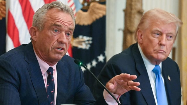 US President Donald Trump (R) listens as US Secretary of Health and Human Services Robert F. Kennedy Jr. speaks at an event.