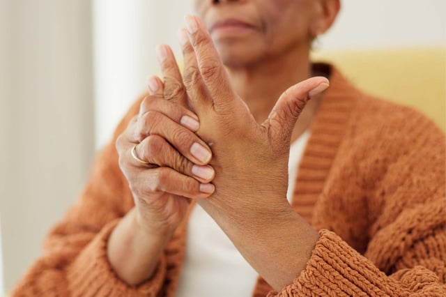 Older woman holding hand in pain.