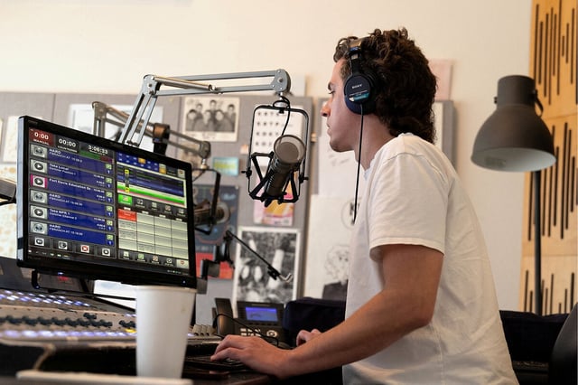 News director Travis Bubenik broadcasts a live news segment over Marfa Public Radio in Marfa, Texas, June 23, 2025. 