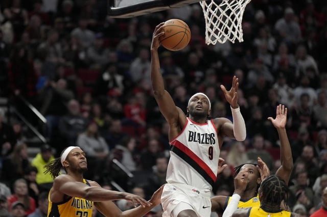 Jan 19, 2024; Portland, Oregon, USA; Portland Trail Blazers small forward Jerami Grant (9) shoots the ball past Indiana Pacers small forward Aaron Nesmith (23, right) during the second half at Moda Center.
