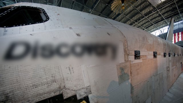 a side view of a space shuttle orbiter with its name digitally blurred out