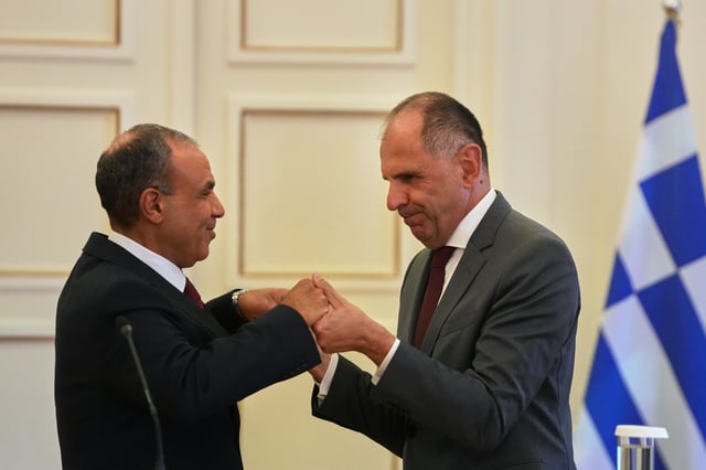 Egyptian Foreign Minister Badr Abdelatty, left, and his Greek counterpart George Gerapetritis shake hands after a news conference in Athens, Greece, Wednesday, Aug. 6, 2025. (AP Photo/Thanassis Stavrakis)