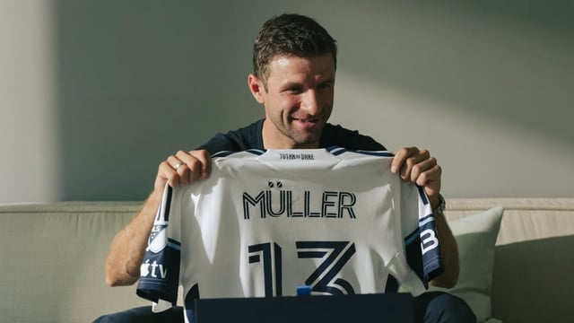 Thomas Müller holds up his #13 Whitecaps jersey, announcing he will join the Vancouver team. 