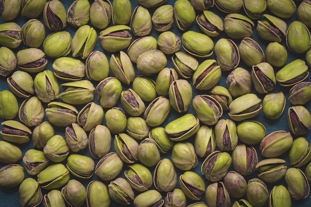 A high-resolution photo of a few pistachios with their shells still intact