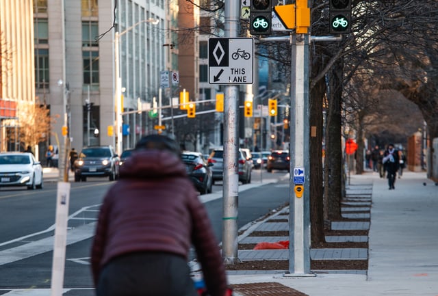 A cyclist rides in a bike lane at St. George St. and Bloor St. West in Toronto on Friday, December 13, 2024. 