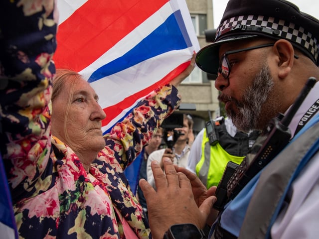 LONDON, ISLINGTON, UNITED KINGDOM - 2025/08/02: A Police liaison officer confronts an anti immigrant demonstrator during the demonstration. Residents protested under the banner 'Thistle Barbican needs to go locals say no'. Right-wing groups and 'Stand up to Racism' held counter-protests outside the hotel, with police ensuring separation. The demonstration was in response to reported crimes by hotel residents and ongoing tensions over migrant accommodation. Early in the afternoon, a group identified as ANTIFA arrived and remained in the centre of the road, prompting police to first move them to the designated protest area and subsequently use force to arrest individuals who did not comply. (Photo by James Willoughby/SOPA Images/LightRocket via Getty Images)