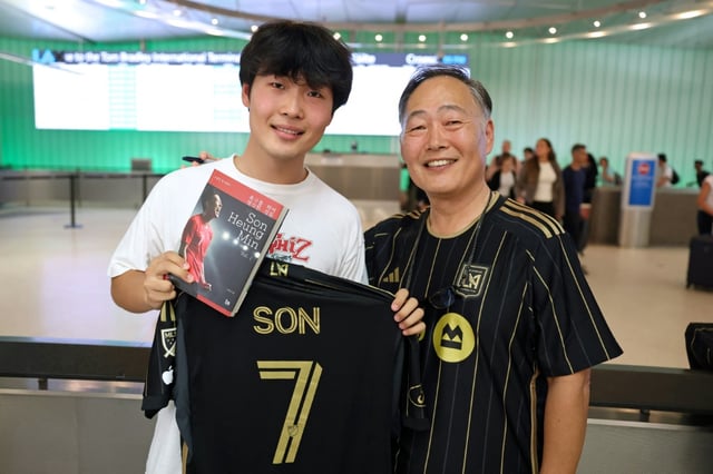 Jun Kwon (g) et son père Hojin Kwon, supporters de la star coréenne Son Heung-min, qui vient de s'engager avec le Los Angeles FC, le 5 août 2025 à l'aéroport de Los Angeles