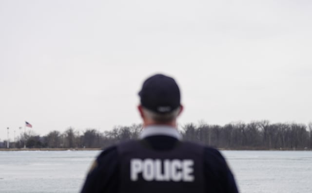 FILE: An RCMP officer in Windsor, Ont. looks over the Detroit River, on Friday, March 7, 2025. THE CANADIAN PRESS/Chris Young