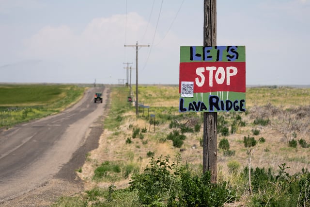 FILE - A tractor travels down Hunt Road in front of a "Let's Stop Lava Ridge" sign near the Minidoka National Historic Site, July 6, 2023, in Jerome, Idaho. (AP Photo/Lindsey Wasson, File)
