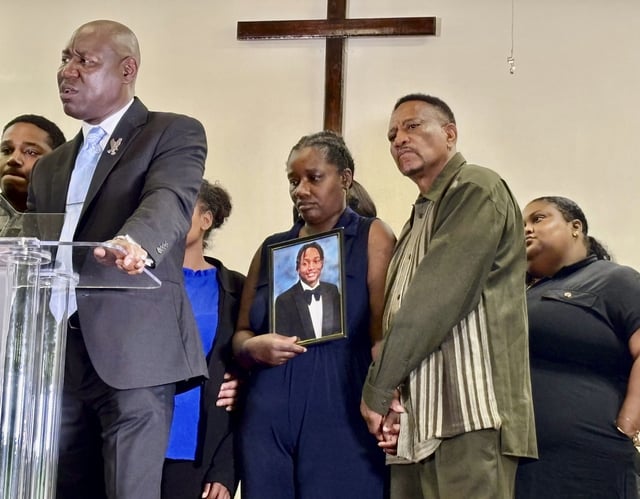Vivian Sterling, center, and William Peoples stand with a photo of their son, Jabari Peoples, as attorney Ben Crump, far left, speaks to reporters during a press conference in Homewood, Ala., Tuesday, July 8, 2025. (AP Photo/Kim Chandler)