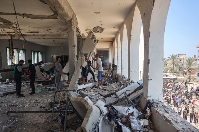 Palestinians clamber over the rubble, after Israel forces attacked the Khadija school, central Gaza, on July 27, 2024. A leading rights group warned that Israel has damaged or destroyed "virtually all" of Gaza's schools.