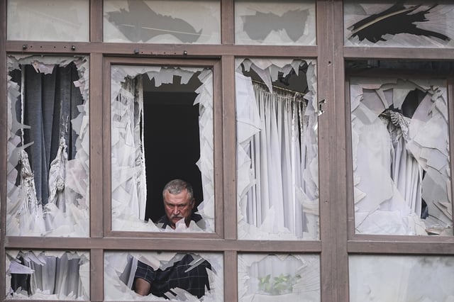 A man stands at the broken windows of his house after a Russian attack in Kyiv, Ukraine, Monday, July 21, 2025. (AP Photo/Efrem Lukatsky)