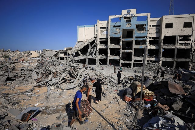 Palestinians inspect the site surrounding an evacuated UNRWA clinic where displaced people were taking shelter, following an overnight Israeli strike, in Gaza City August 6, 2025. REUTERS/Dawoud Abu Alkas