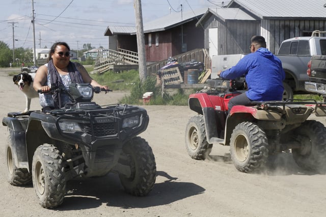 Residents ride all-terrain vehicles on the dusty streets of Kwethluk, Alaska, on June 19, 2025. (AP Photo/Mark Thiessen)