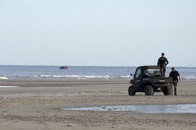 ARCHIVO - Gendarmes franceses observan una embarcación con migrantes a bordo desde la playa de Ecault, en Francia, el 4 de julio de 2025. (AP Foto/John Leicester, archivo)