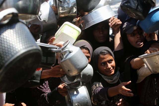 Palestinians wait to receive food from a charity kitchen, amid a hunger crisis, in Khan Younis, southern Gaza Strip, August 4, 2025. REUTERS/Hatem Khaled/File Photo