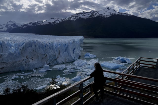 FILE - A tourist watches the Perito Moreno Glacier at Los Glaciares National Park, near El Calafate, Argentina, Nov. 1, 2021. (AP Photo/Natacha Pisarenko, File)