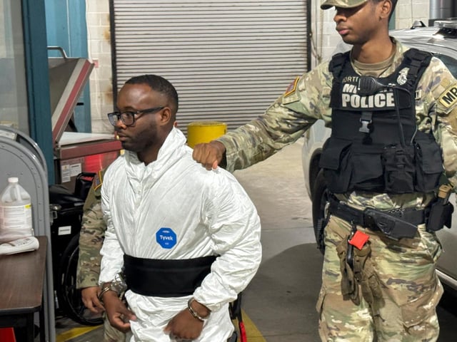 El sargento Quornelius Radford, sospechoso de disparar contra cinco soldados en Fort Stewart, es escoltado por policías militares hacia una sala de registro de la cárcel del condado de Liberty en Hinesville, Georgia, el miércoles 6 de agosto de 2025. (AP Foto/Lewis M. Levine)