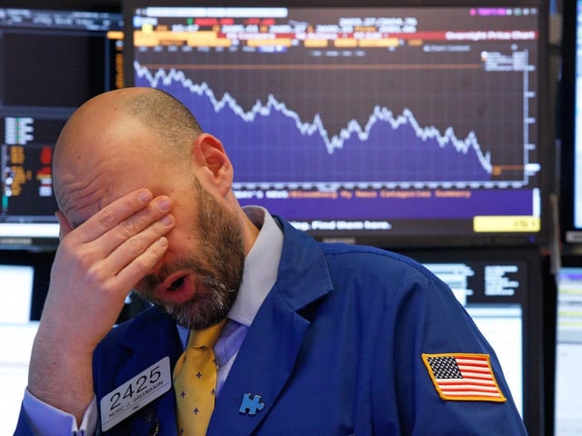 A trader reacts near the end of the day on the floor of the New York Stock Exchange in New York