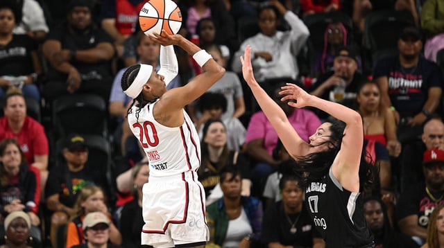 Jul 10, 2025; Washington, District of Columbia, USA; Washington Mystics guard Brittney Sykes (20) attempts a jump shot over Las Vegas Aces center Megan Gustafson (17) during the fourth quarter at EagleBank Arena.