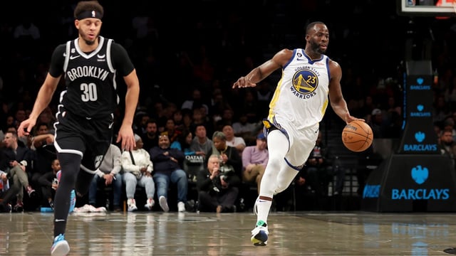 Dec 21, 2022; Brooklyn, New York, USA; Golden State Warriors forward Draymond Green (23) brings the ball up court against Brooklyn Nets guard Seth Curry (30) during the second quarter at Barclays Center. Mandatory Credit: Brad Penner-Imagn Images