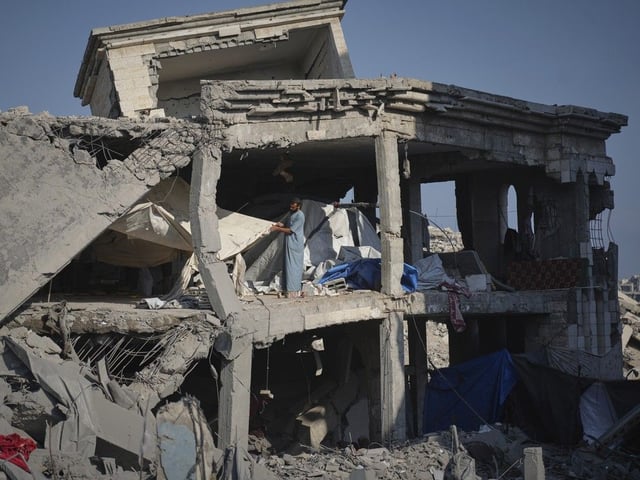 People inspect the damage at the Sheikh Radwan al-Taba UNRWA clinic following an Israeli army bombardment in Gaza City Wednesday, Aug. 6, 2025. 