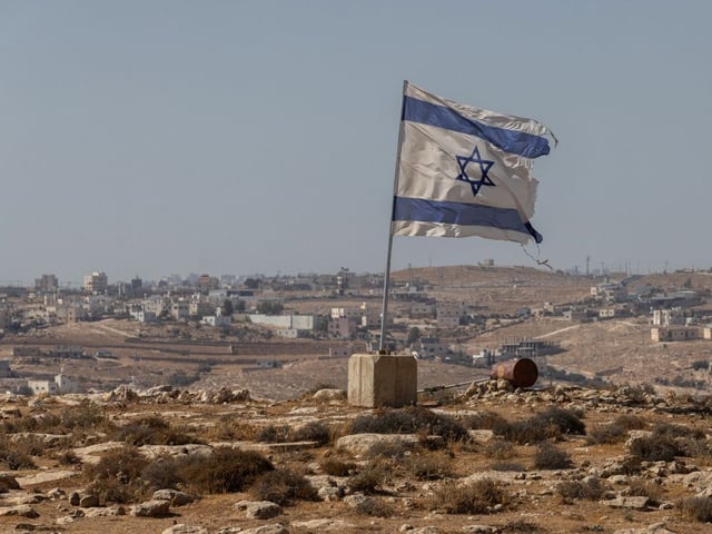 An Israeli flag flies along a highway near the settlement of Carmel, in the West Bank on Aug. 4.