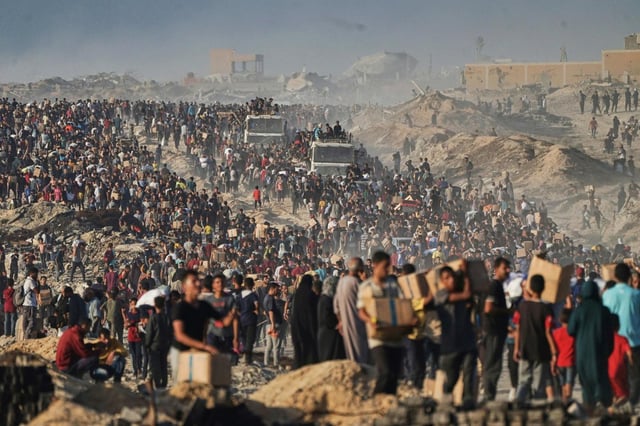Palestinians carry humanitarian aid from a World Food Program convoy that was heading to Gaza City, June 16, 2025. (AP Photo/Jehad Alshrafi, File)
