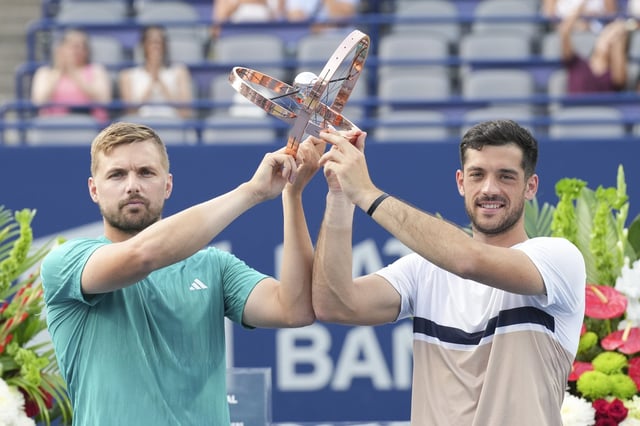 Lloyd Glasspool, left, and Julian Cash of Great Britain lift the Men's Doubles trophy after beating Joe Salisbury and Neal Skupski of Britain at the National Bank Open in Toronto on Thursday, August 7 , 2025. THE CANADIAN PRESS/Chris Young