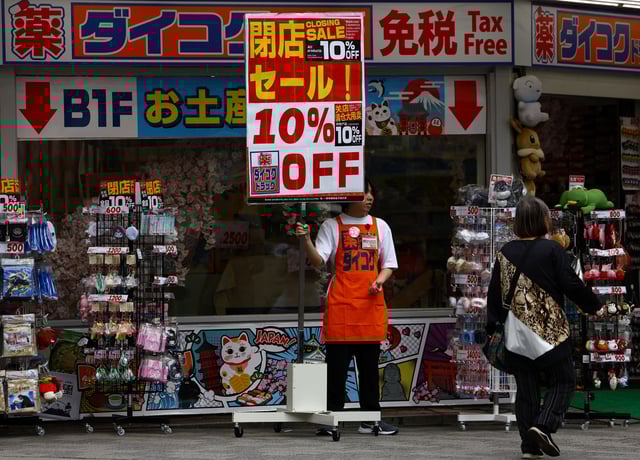 A store staff member tries to attract customers outside a store in Tokyo, Japan, May 15, 2025.  REUTERS/Issei Kato/ File Photo