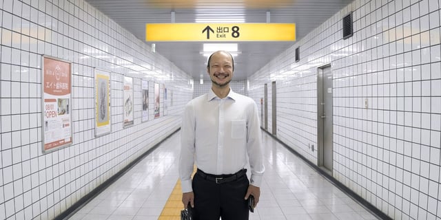 Kazunari Ninomiya as Lost Man standing and smiling in a hallway in "Exit 8" 