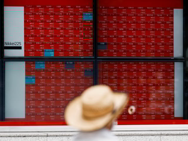 A man looks at an electronic board displaying the Nikkei stock average outside a brokerage in Tokyo, Japan, August 6, 2024. REUTERS/Willy Kurniawan/File Photo