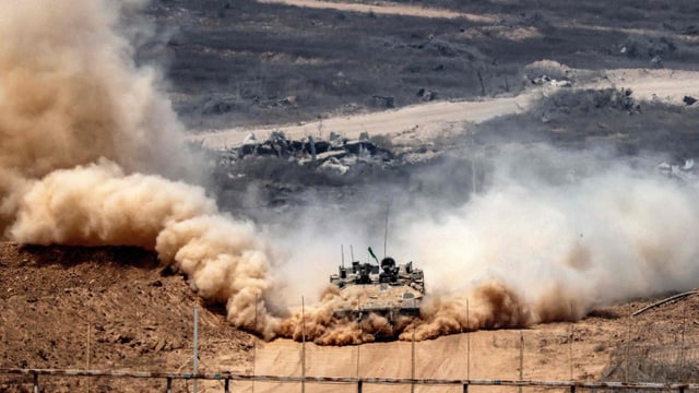An Israeli army infantry-fighting vehicle (IFV) leaves a cloud of dust as it moves at a position along Israel's southern border with the Gaza Strip.