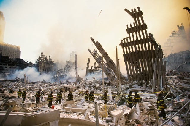 FDNY first responders walk amidst the rubble of the World Trade Center as it smolders following a terrorist attack in N.Y., September 11, 2001.