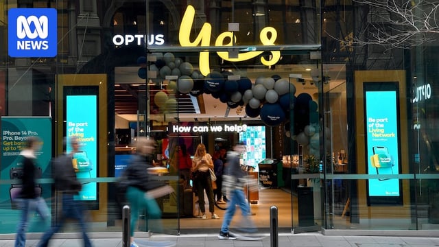 People walk past an Optus store in Sydney.