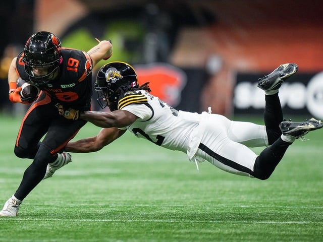  B.C. Lions’ Ayden Eberhardt, left, breaks a tackle by Hamilton Tiger-Cats’ Will Sunderland during the second half of a CFL football game, in Vancouver, on Friday, Sept. 27, 2024.