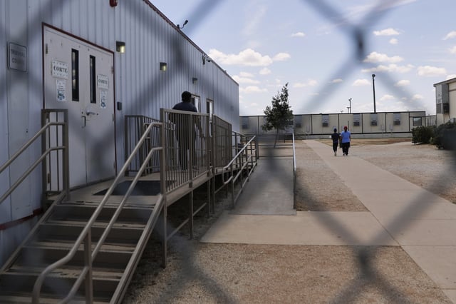 FILE - Immigrants seeking asylum walk through the ICE South Texas Family Residential Center on Aug. 23, 2019, in Dilley, Texas. (AP Photo/Eric Gay, File)