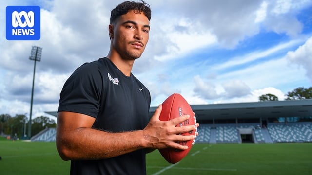 Jordan Petaia poses with an American football for a photograph.