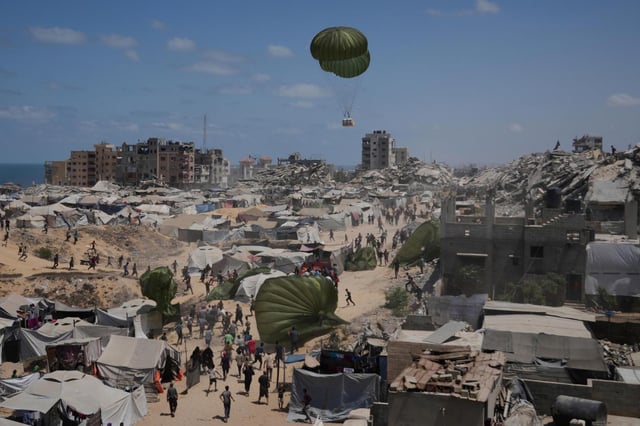 Palestinos corren para recoger ayuda humanitaria lanzada con paracaídas desde el aire, en la Ciudad de Gaza, en el norte de la Franja de Gaza, el 7 de agosto de 2025. (AP Foto/Jehad Alshrafi)