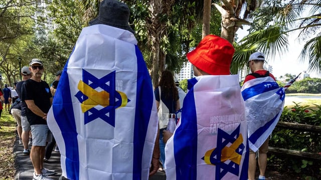 Demonstrators wear Israeli flags featuring a yellow ribbon representing solidarity with the hostages still being held in Gaza during a "Run for Their Lives" walk at Aventura Circle on June 8, 2025, in Aventura, Florida. Photo: D.A. Varela/Miami Herald/Tribune News Service via Getty Images