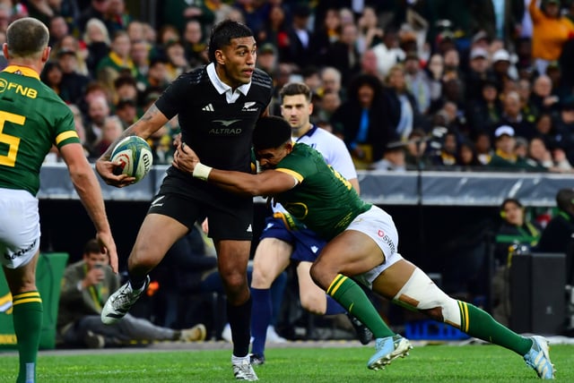 Rieko Ioane of New Zealand fends of a tackle by South Africa's Sacha Feinberg-Mngomezulu during a 2024 Rugby Championship encounter.